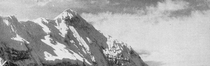 Verschillende bergbeklimmers beklimmen een steile, met sneeuw bedekte berghelling en laten in het felle daglicht voetafdrukken en sporen achter. Het tafereel is dramatisch en vanuit een schuine hoek g