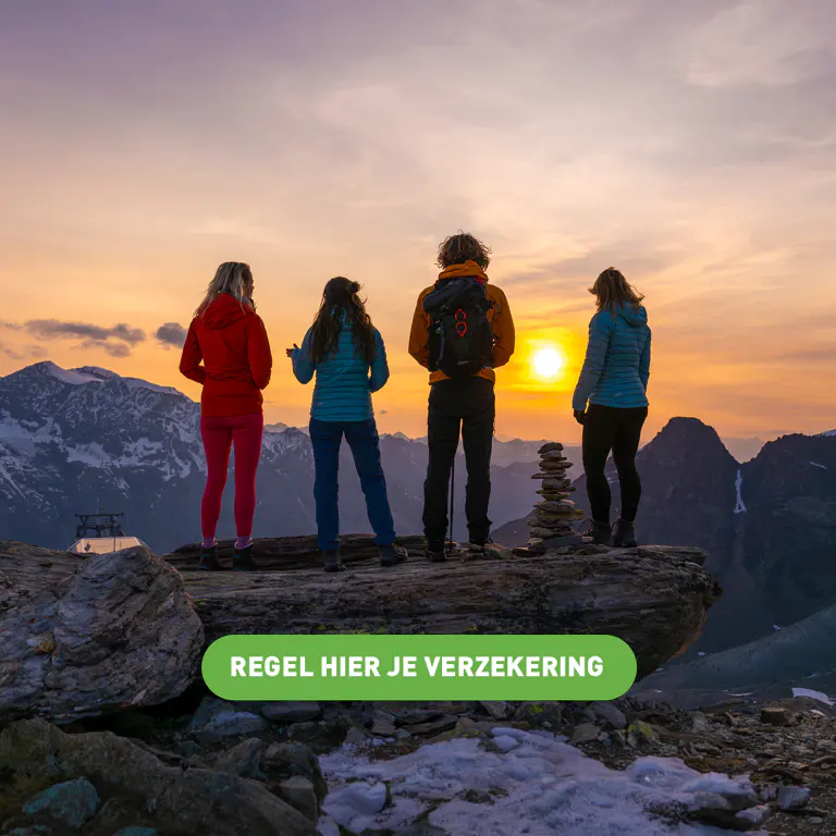Vier wandelaars staan bij zonsondergang op een bergtop, met een bordje waarop staat: REGEL HIER JE VERZEKERING.