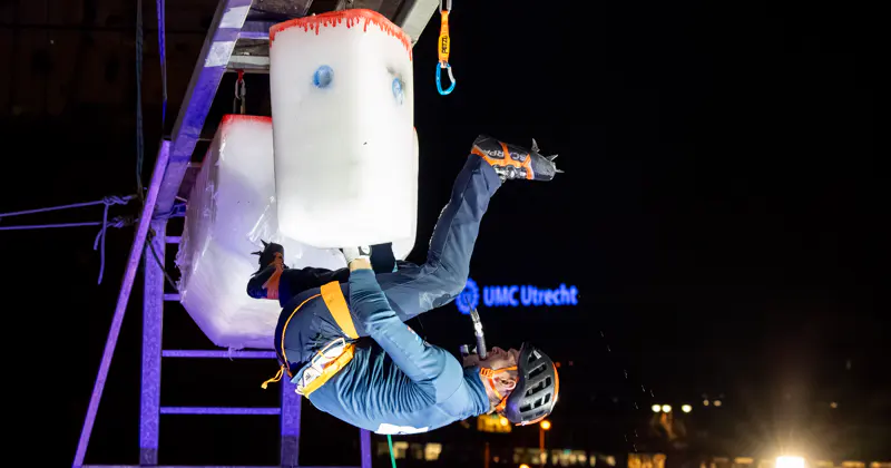 Tijdens de finale van de Continental Cup hangt een heren-finalist in het dak van klimmuur Kalymnos aan een ijston. 